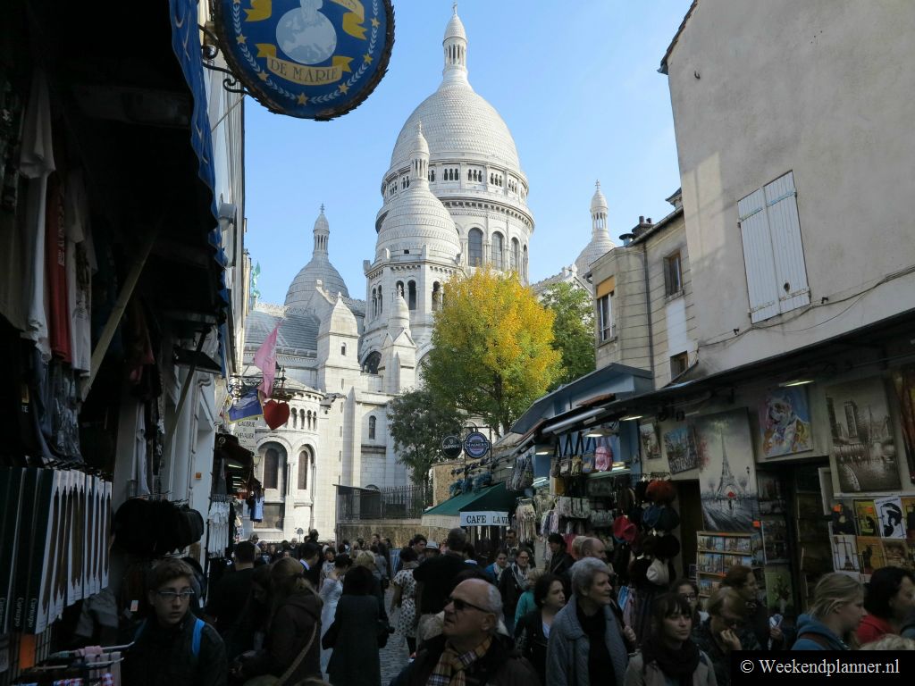 Naast de Sacré-Coeur loop je via een drukke straat naar de schildersmarkt Place du Tertre. In dit straatje zijn veel souvenirwinkels en cafés. De eerste schilders, misschien met alpinopetje, zullen hier al hun diensten aanbieden.